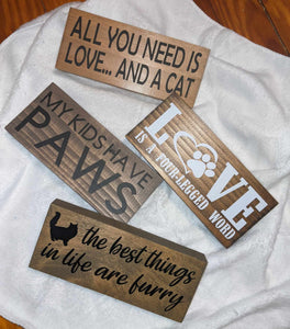 Cat Shelf Sitter Signs: Add a unique and adorable touch to your home decor with these charming cat-themed signs. Perfect for shelves or desks. Available in 4 different sayings and 3 stain options. Each sign measures approximately 2.5 inches by 6 inches by 0.75 inches. Ideal gift for cat lovers!