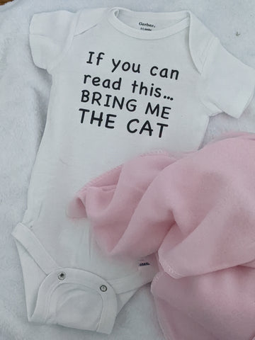 White baby onesie with black lettering, saying If you can read this bring me the cat