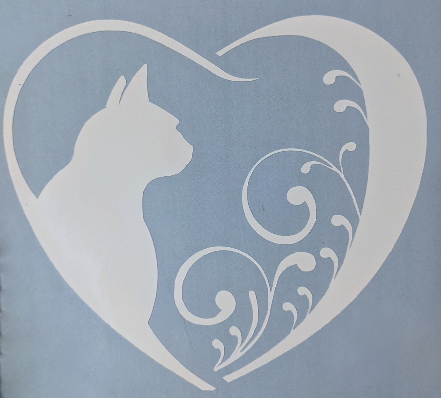 white vinyl cat silhouette inside a heart shaped car window decal on light blue backing