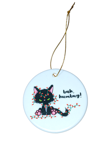 Bah Humbug Ceramic Cat Ornament: Add a whimsical touch to your Christmas tree decor with our 2.75-inch ceramic ornament. Featuring a charming design of a mischievous black cat entangled in Christmas lights, exclaiming 'Bah, humbug!' Crafted with attention to detail, this ornament showcases the adorable cat design on both sides. Perfect for cat lovers or anyone seeking unique holiday decor. Make your Christmas tree stand out with our Bah Humbug Ceramic Cat Ornament.