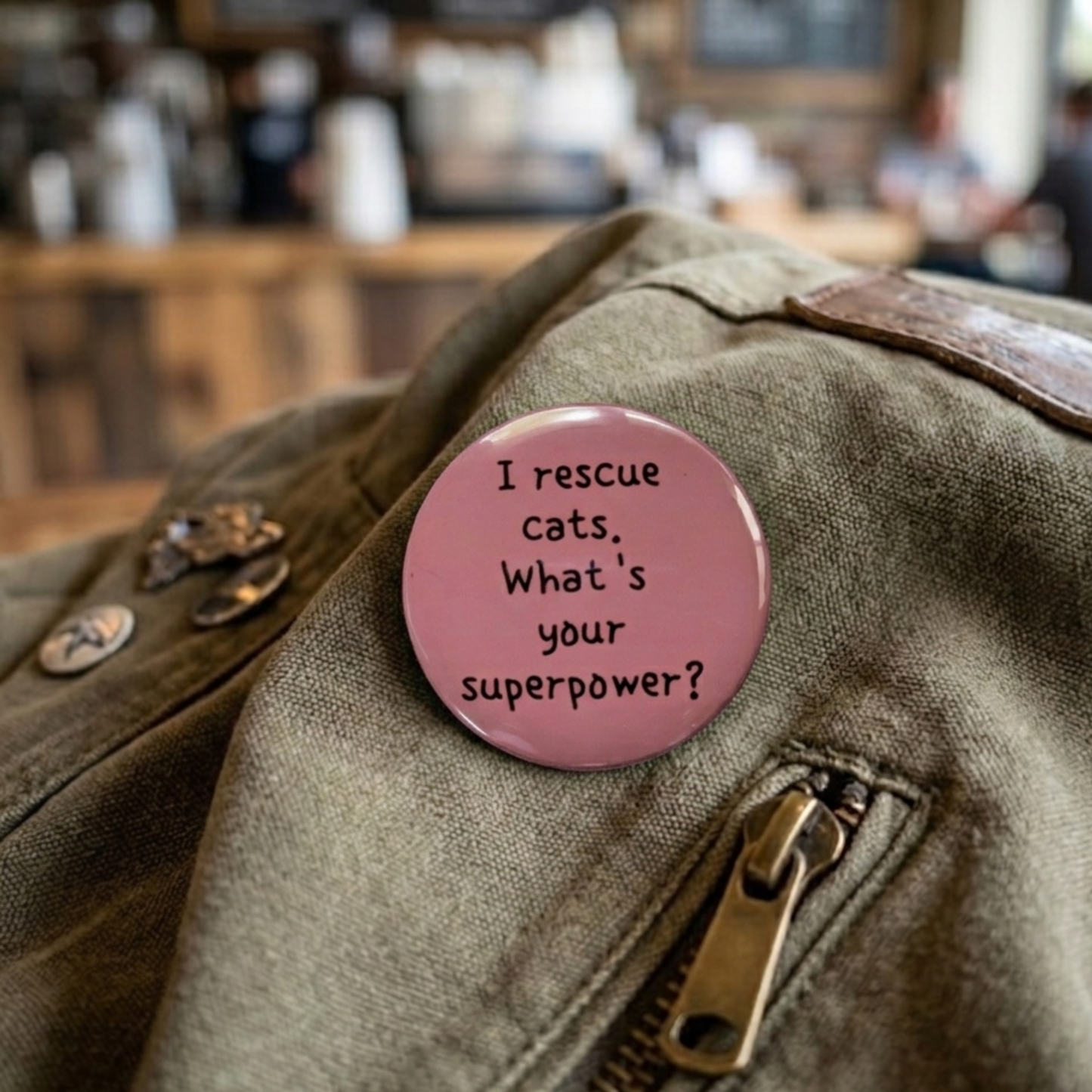 Pink button with text on a jacket in a blurred indoor setting