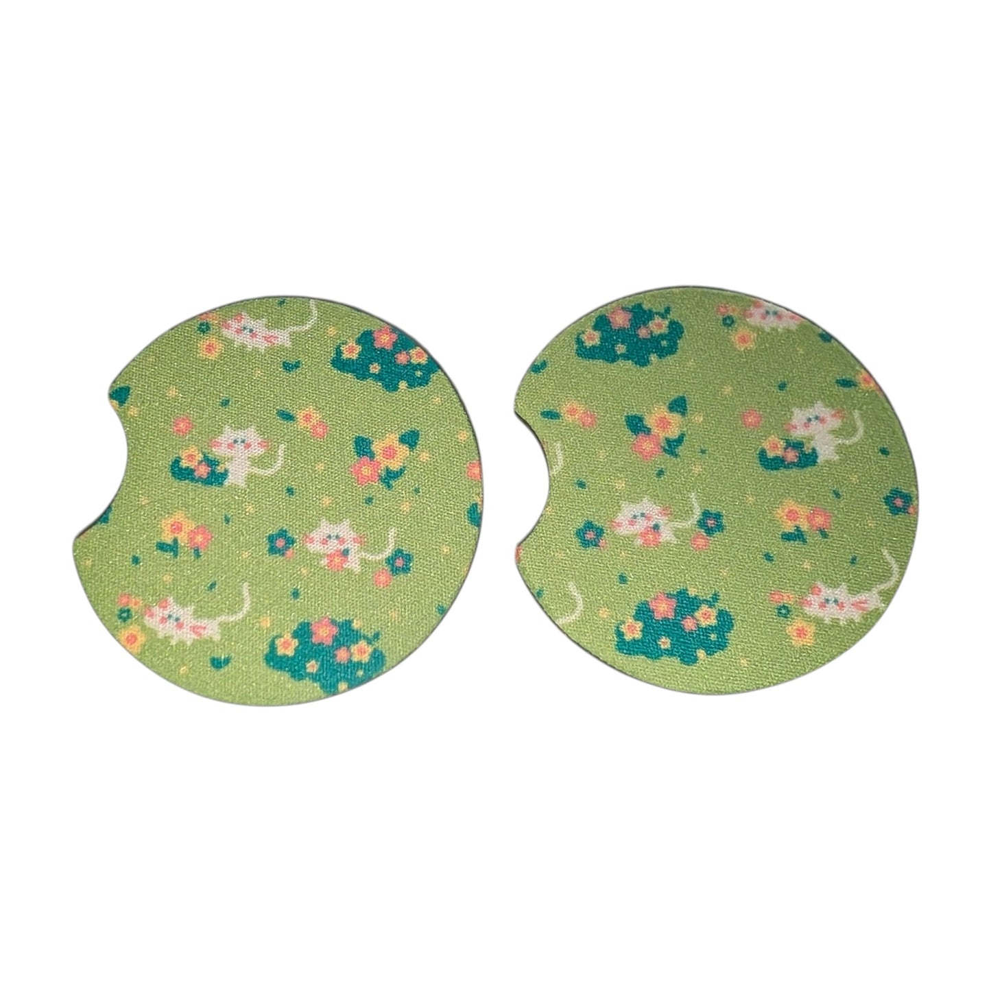 Two green car coasters with cat and flower pattern on a white background