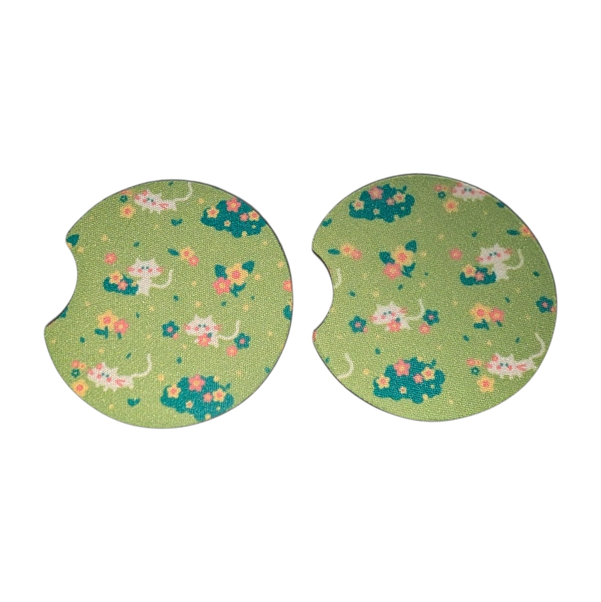 Two green car coasters with cat and flower pattern on a white background