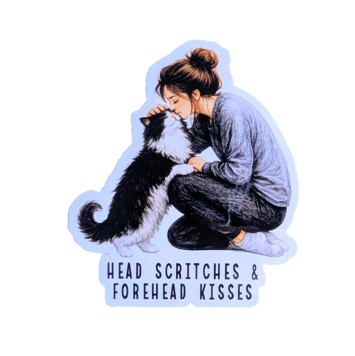 A die-cut sticker featuring an illustration of a woman crouching and kissing the head of a black-and-white cat, with the text 'HEAD SCRITCHES & FOREHEAD KISSES' below. The sticker is shown on a plain white background.
