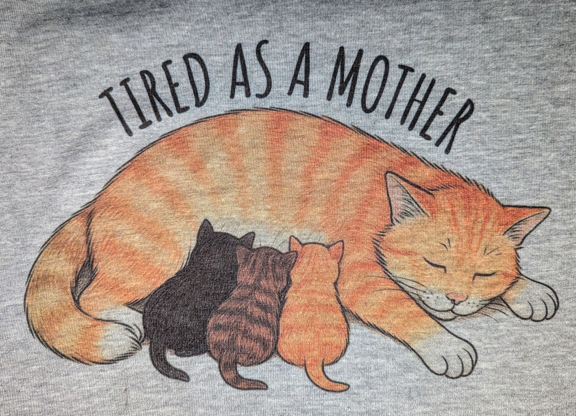 Gray t-shirt with an illustration of a cat and three kittens and text 'TIRED AS A MOTHER' above.
