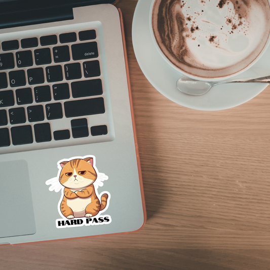 Laptop with a 'Hard Pass' cat sticker on a wooden desk next to a cup of coffee.