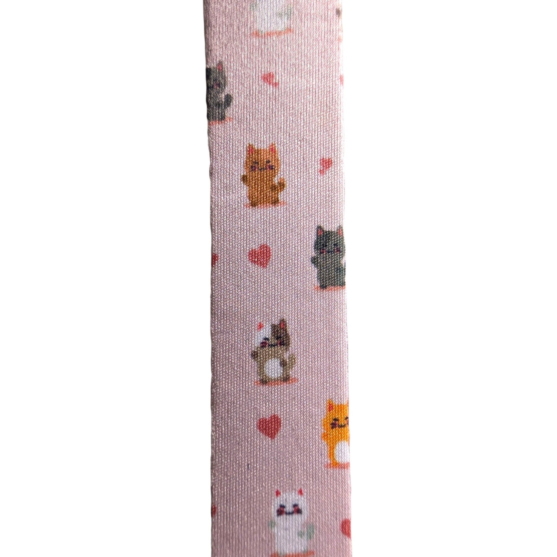 A close-up vertical view of a light pink fabric strap or band printed with small cartoon cats and red hearts on a white background.