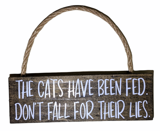 Funny cat wall sign that says The Cats Have Been Fed on rustic wood