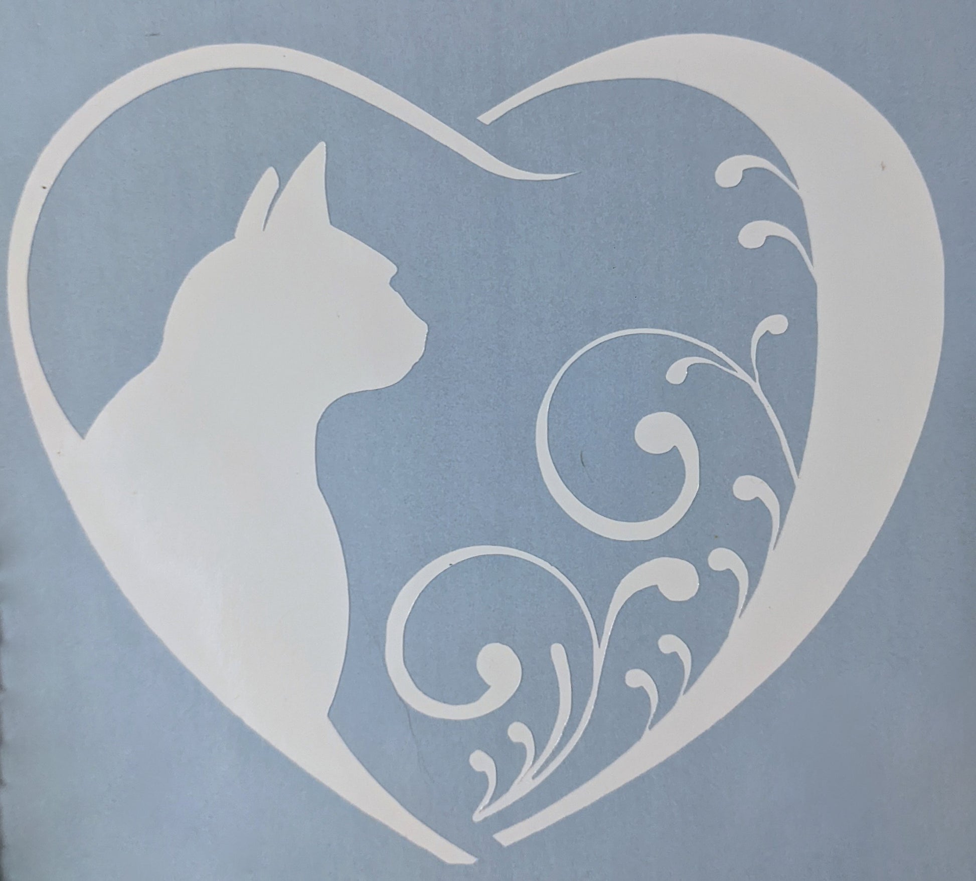 white vinyl cat silhouette inside a heart shaped car window decal on light blue backing